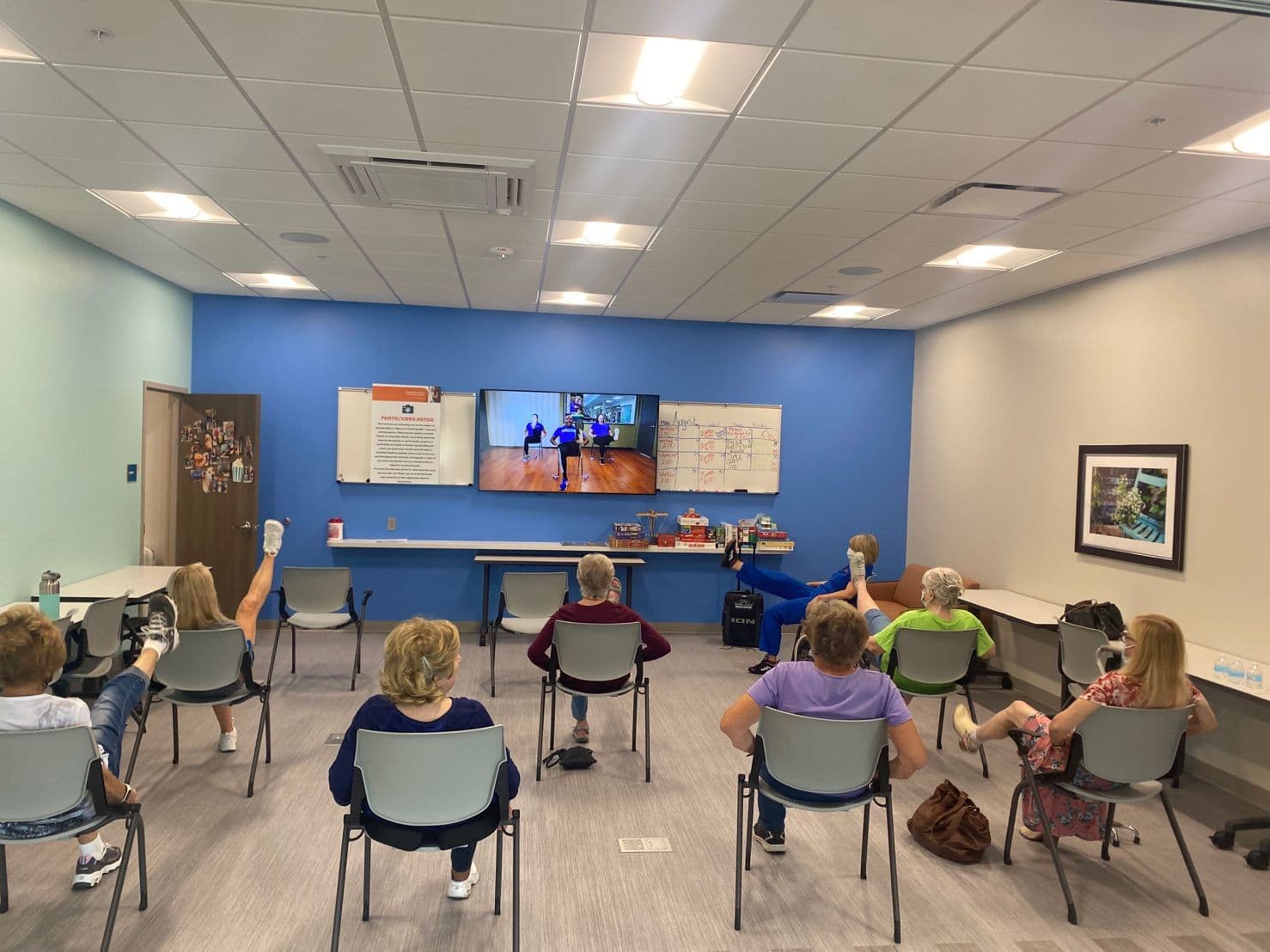 Mga Miyembro ng ArchWell Health sa Kansas City na lumalahok sa isang chair yoga class sa gitna.